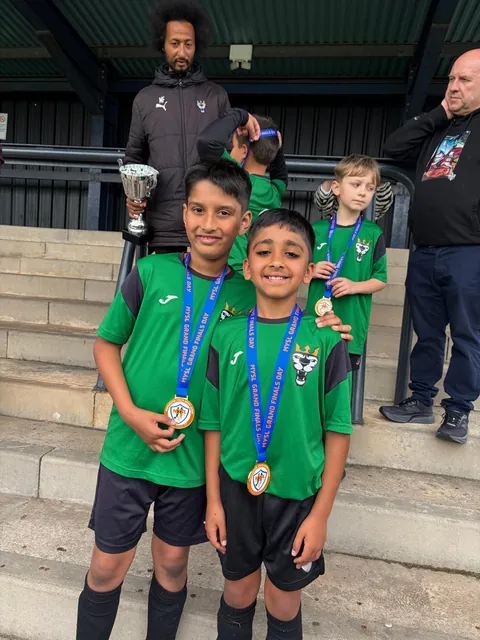 Two players with medals and the cup