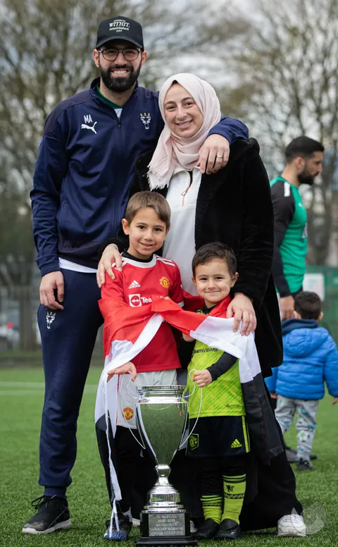 A family with the championship trophy on matchday