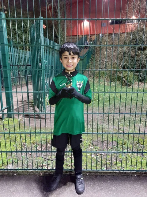 A young Hawks player in FC Babylon kit holding his trophy